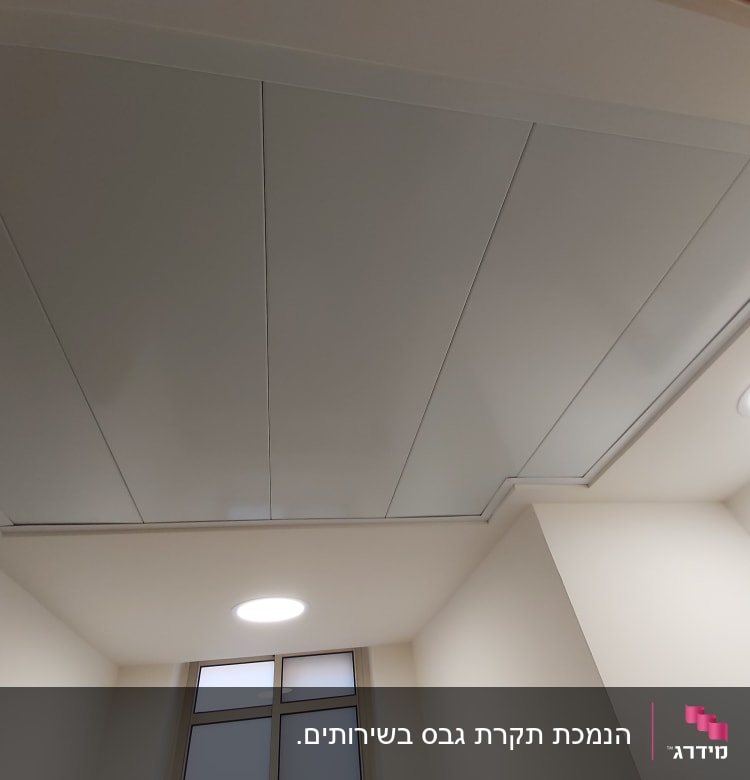 תקרת גבס עם לוחות לבנים ותאורה עגולה